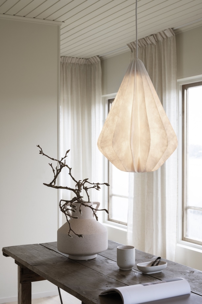 Papierowa lampa wabi sabi nad stołem daje miękkie, delikatne światło