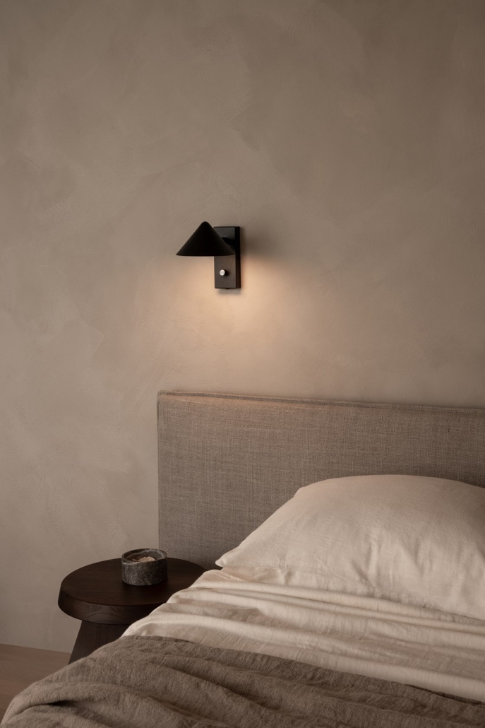 Minimalistyczny nowoczesny kinkiet przy łóżku w sypialni