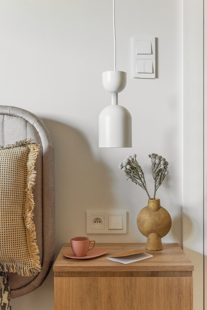 Metalowa lampa wisząca przy łóżku w sypialni - styl minimalistyczny